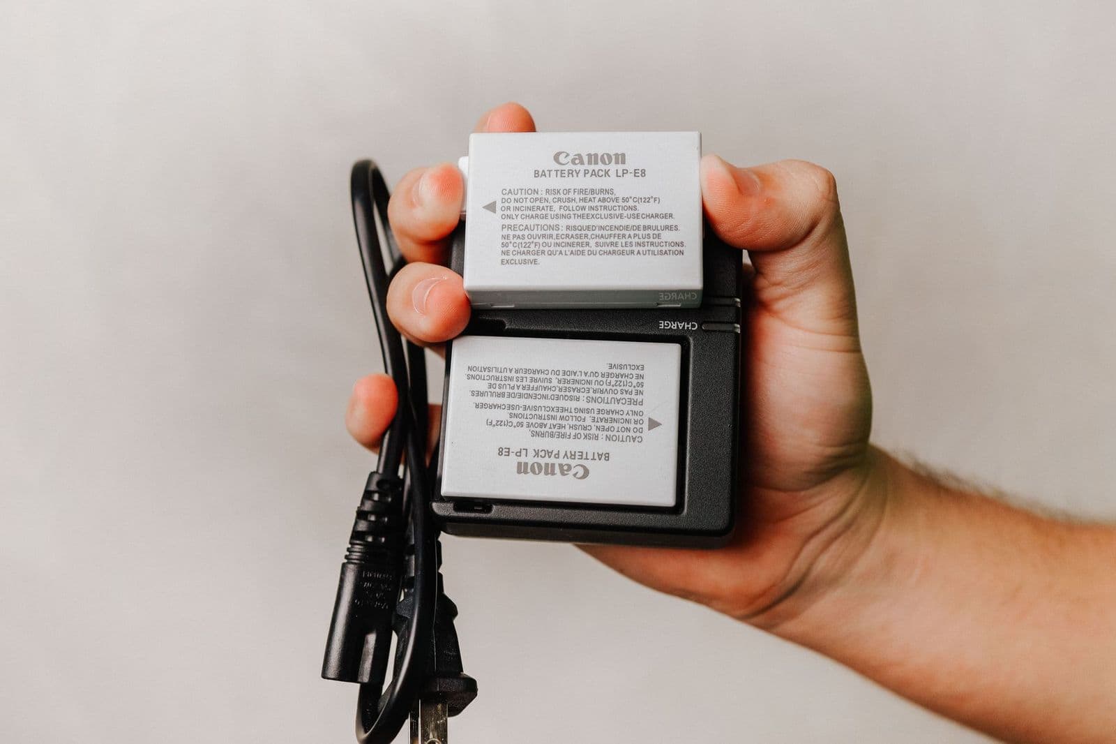 Best batteries for digital cameras, AA cells and a camera battery pack on a table